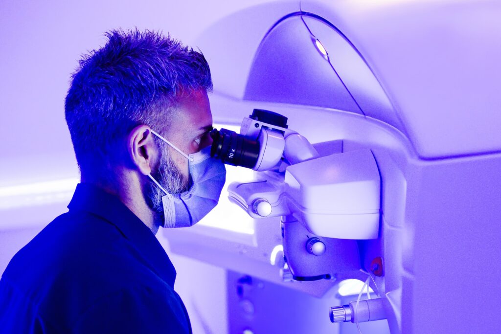 person looking through microscope